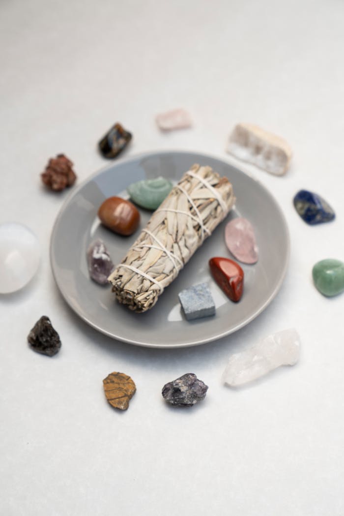 Flat lay of sage bundle and healing crystals for spiritual rituals on a plate, ideal for mindfulness and energy cleansing.